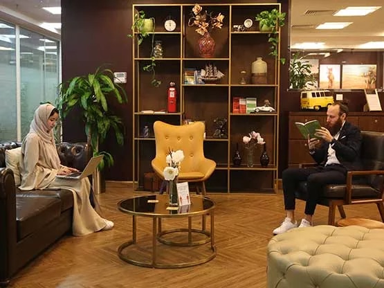 A Warm and inviting Servcorp business lounge, where two professionals are comfortably seated in a tastefully decorated space with elegant furnishings